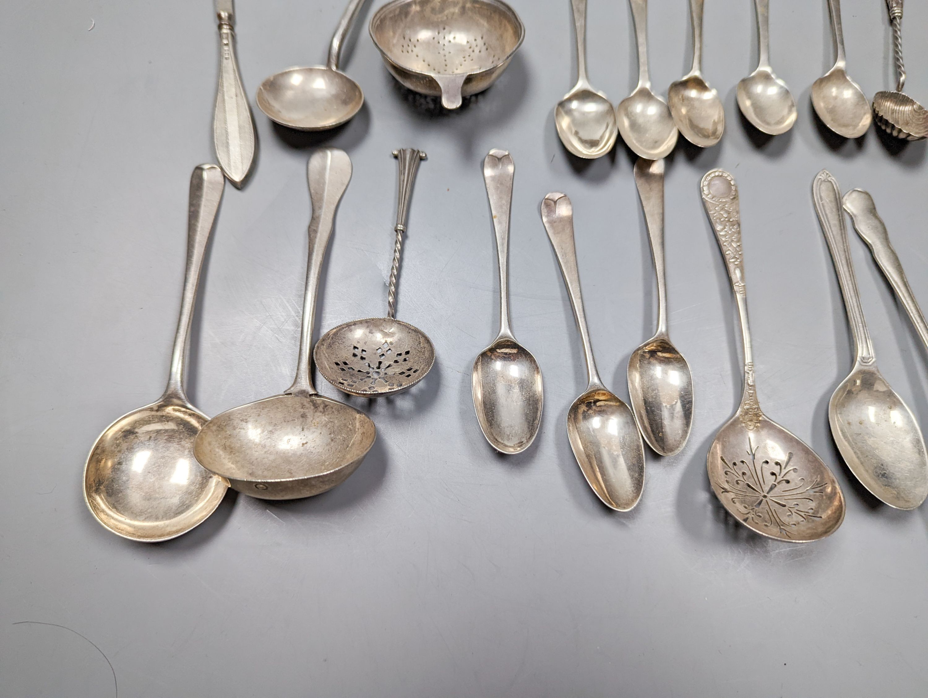 A mixed quantity of 18th, 19th and 20th century silver flatware, including tablespoons, teaspoons, sauce ladles, a 900 standard cake slice, two plated spoons and a nail implement